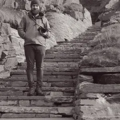 James on weathered stone steps with camera