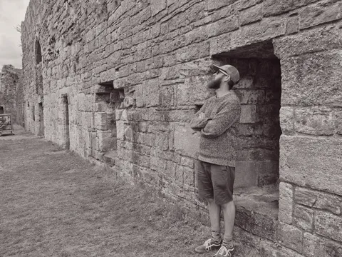 James examining stone wall at castle fortress