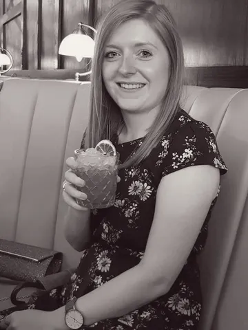 Laura with cocktail at restaurant booth