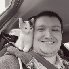 Phill with kitten on shoulder in car