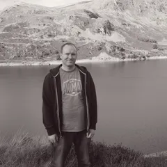 Steven by lake with mountains reflected in water