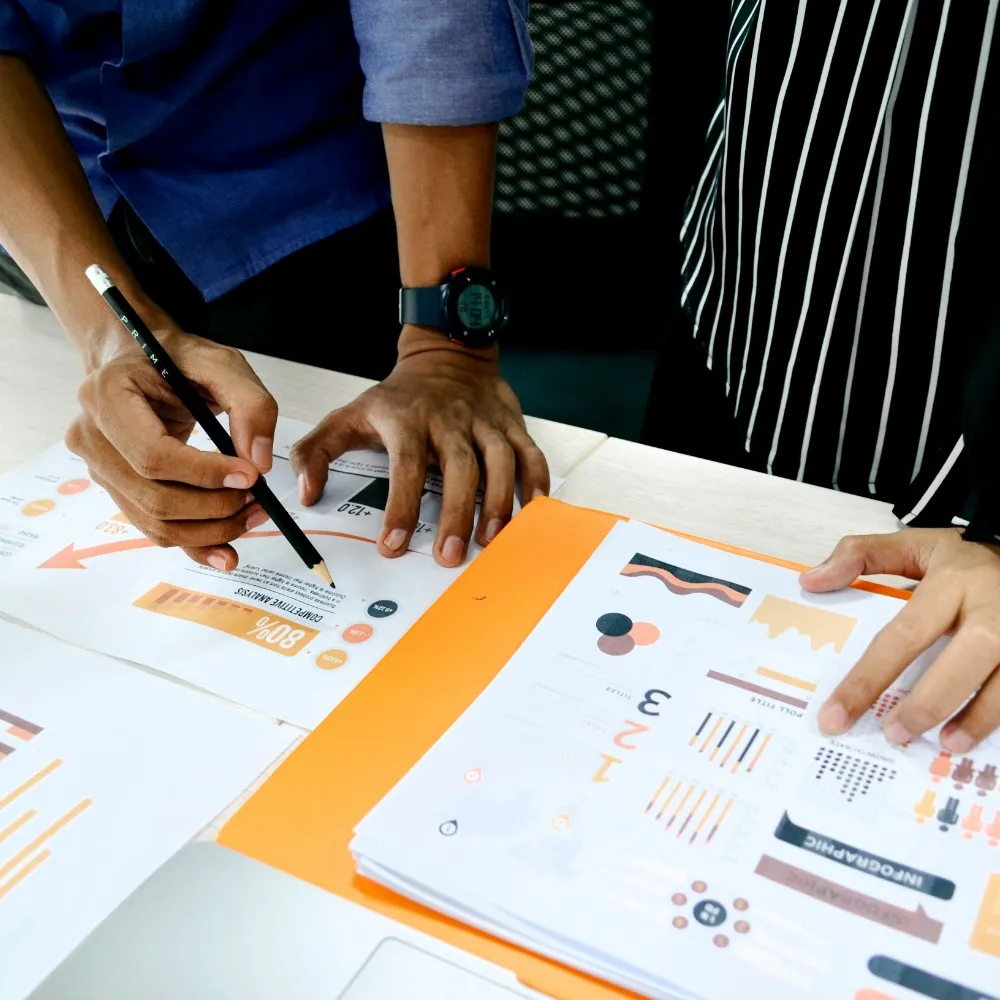 Two people analysing data on sheets of paper
