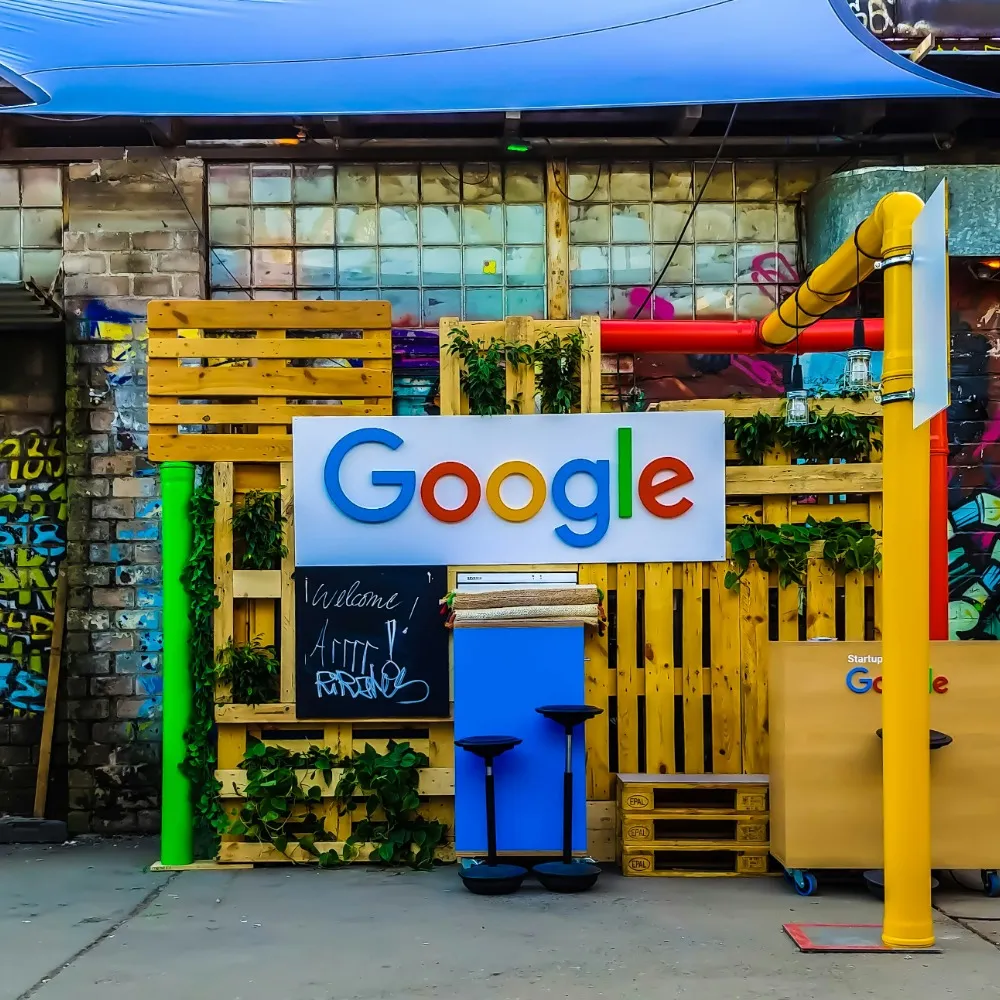 The google sign against yellow wooden pallets and a brick wall