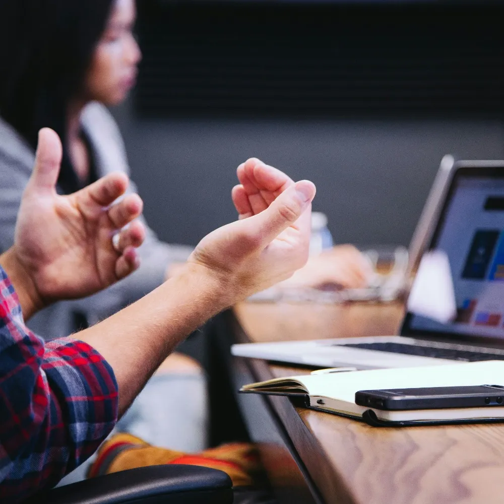 A man in a meeting with his laptop and phone