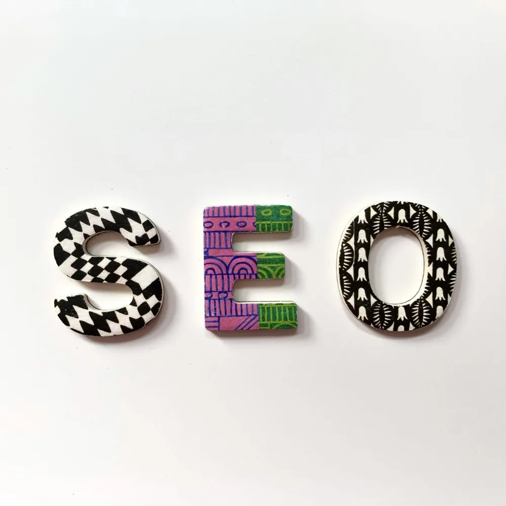 The wording 'SEO' on a white background. Each letter is a different pattern.